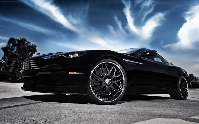 Black sports car under dramatic sky