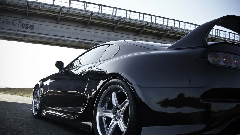 Black sports car under overpass