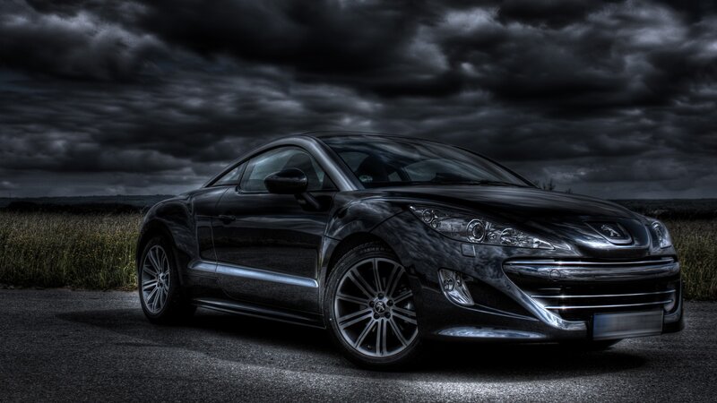 Black sports car under stormy sky