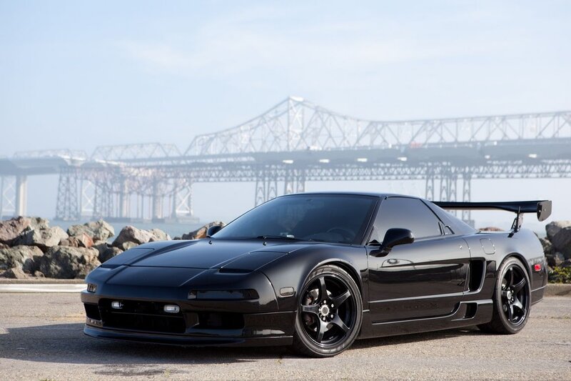 Black sports car with bridge in background