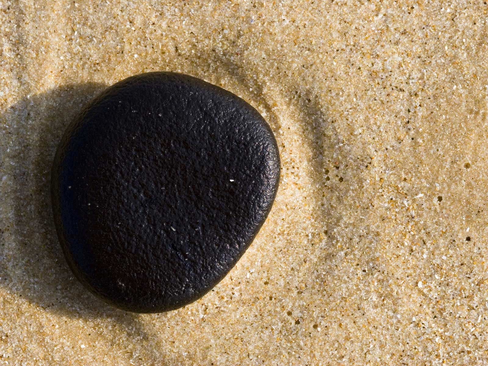 black stone on sandy beach