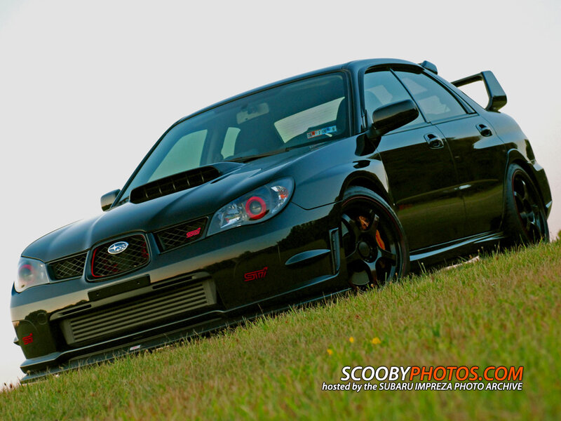 black subaru impreza on grass