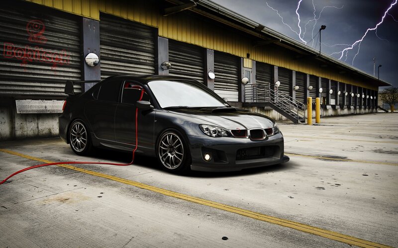 Black Subaru in stormy parking lot