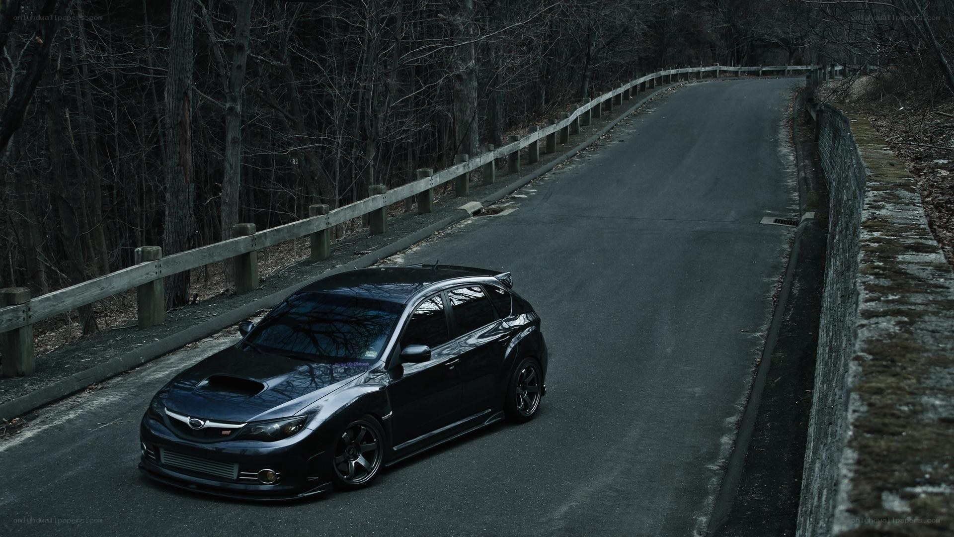 black subaru on a forest road