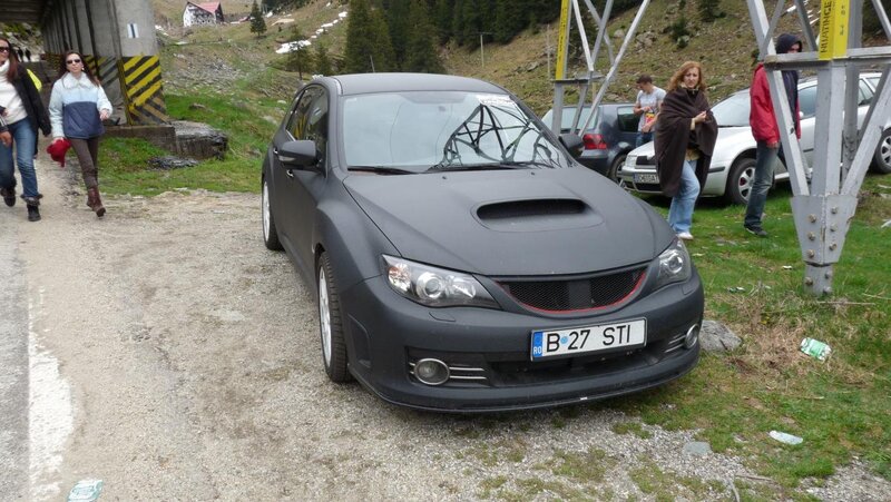 Black Subaru on a mountain road
