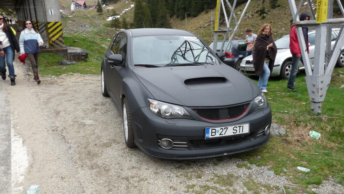 Black Subaru on a mountain road
