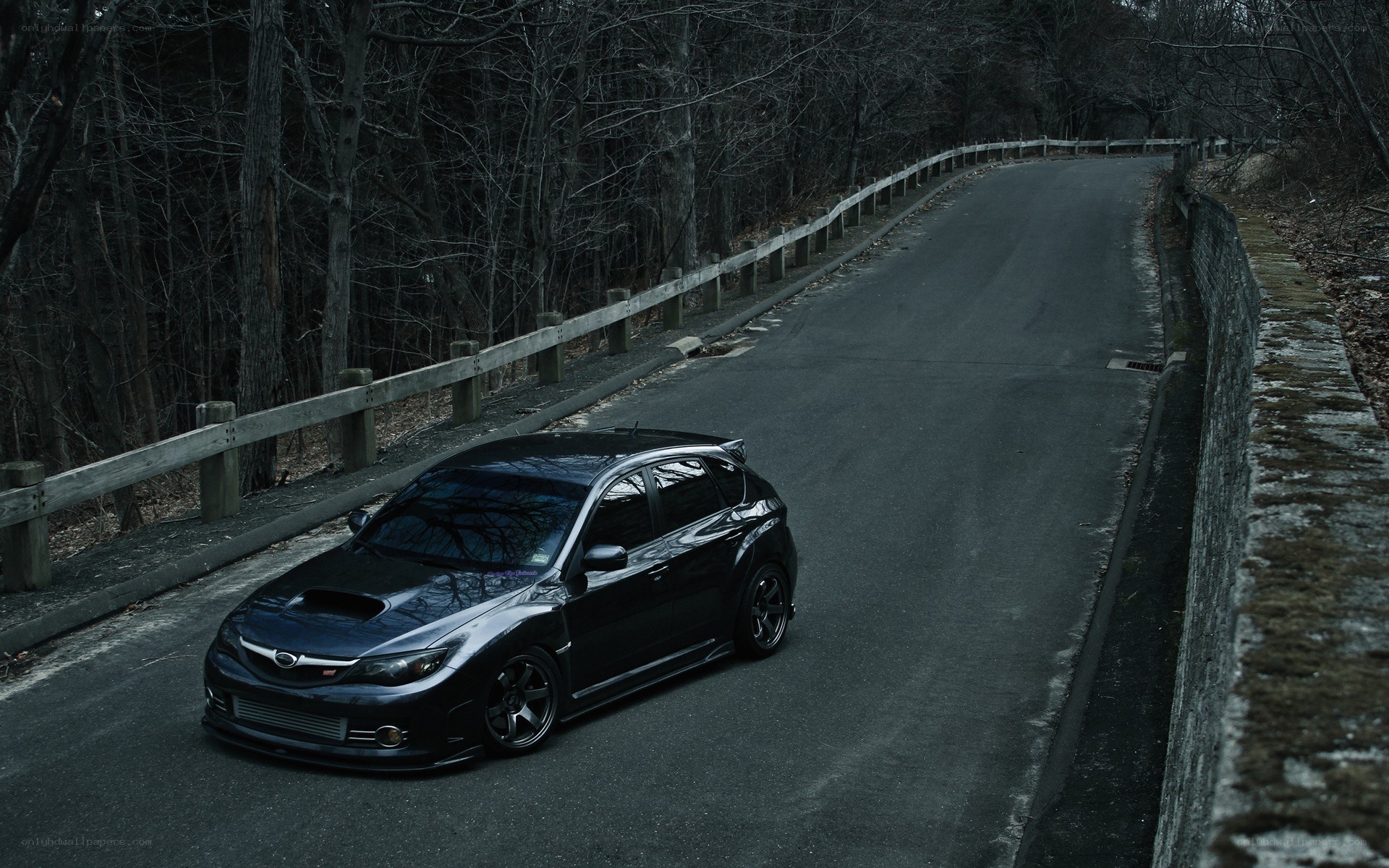 black subaru on a winding road
