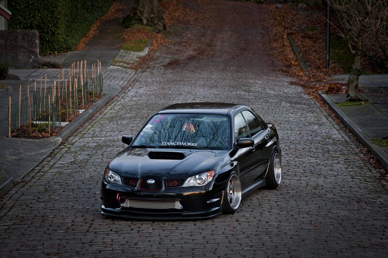black subaru on cobblestone street