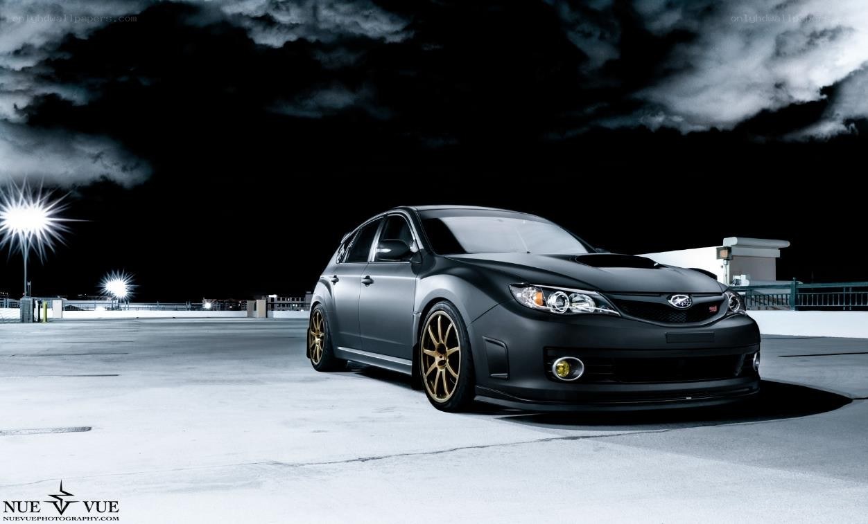 Black Subaru on rooftop at night