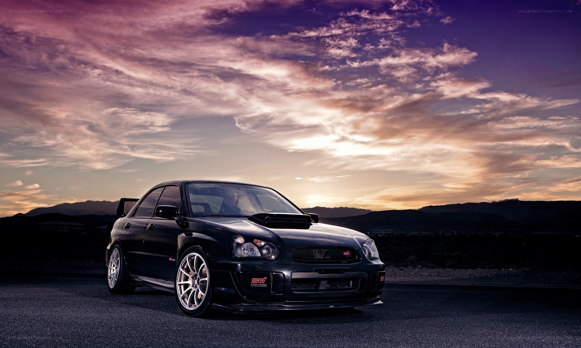 black subaru sti at sunset