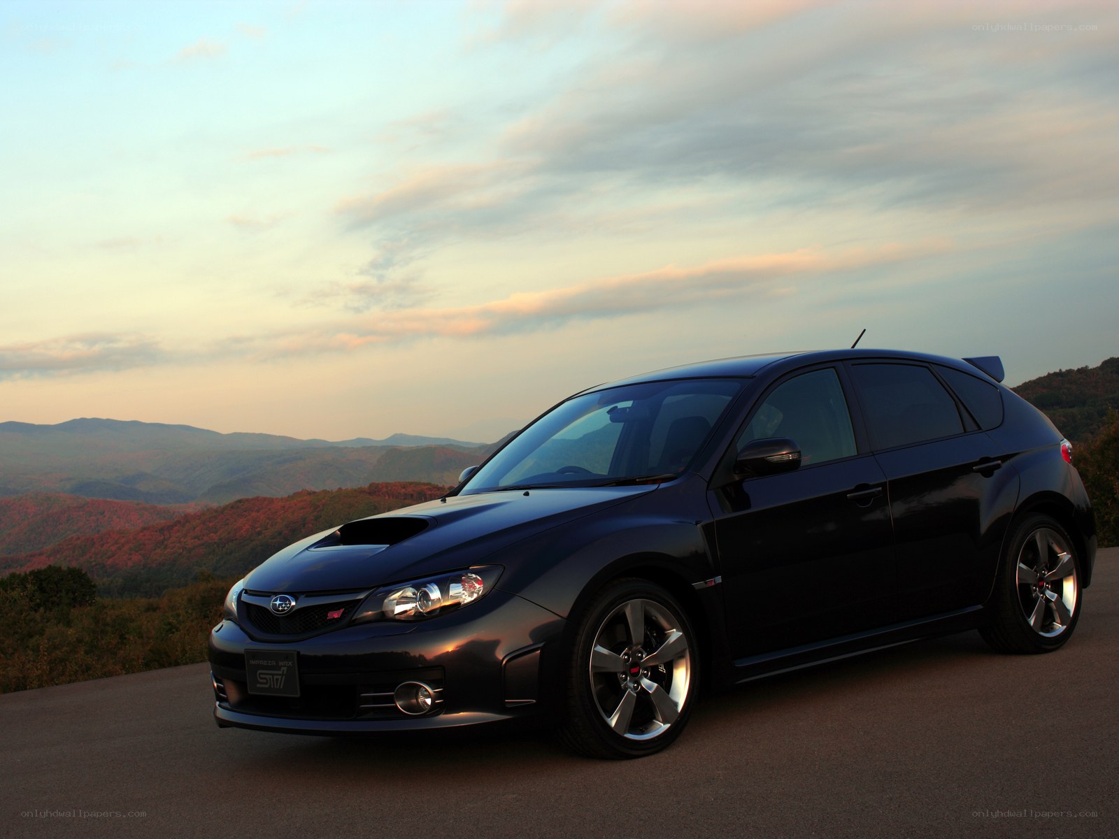 Black Subaru STI on a mountain road