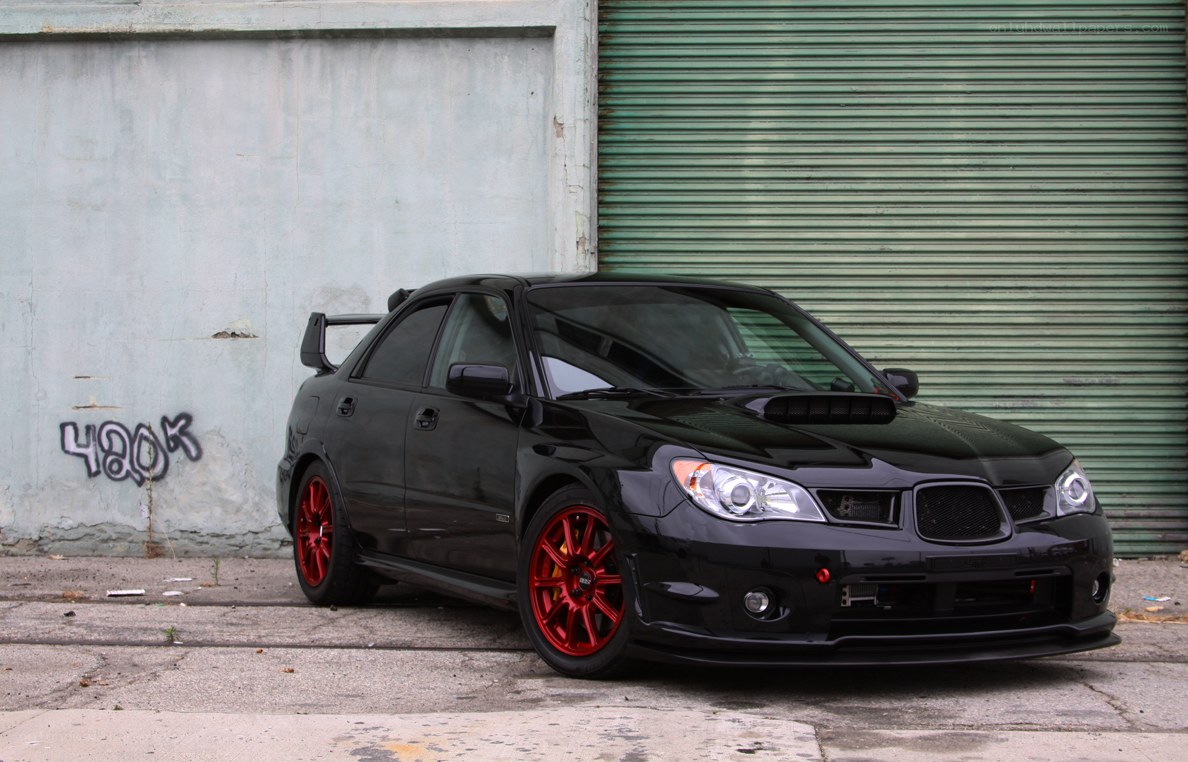 black subaru with red wheels