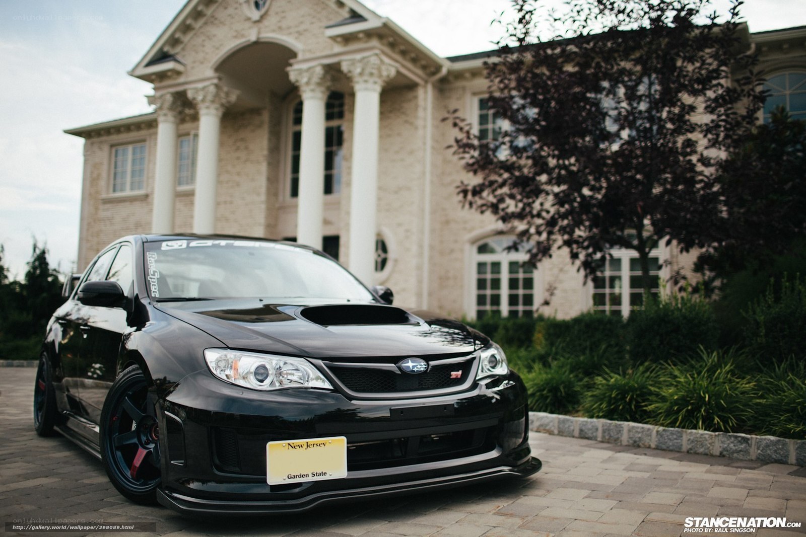 Black Subaru WRX STI in front of mansion
