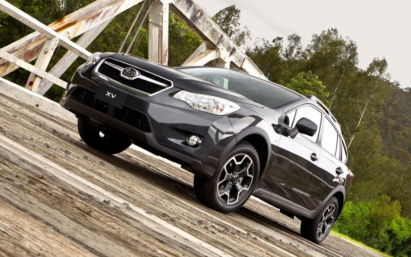 Black Subaru XV on wooden bridge