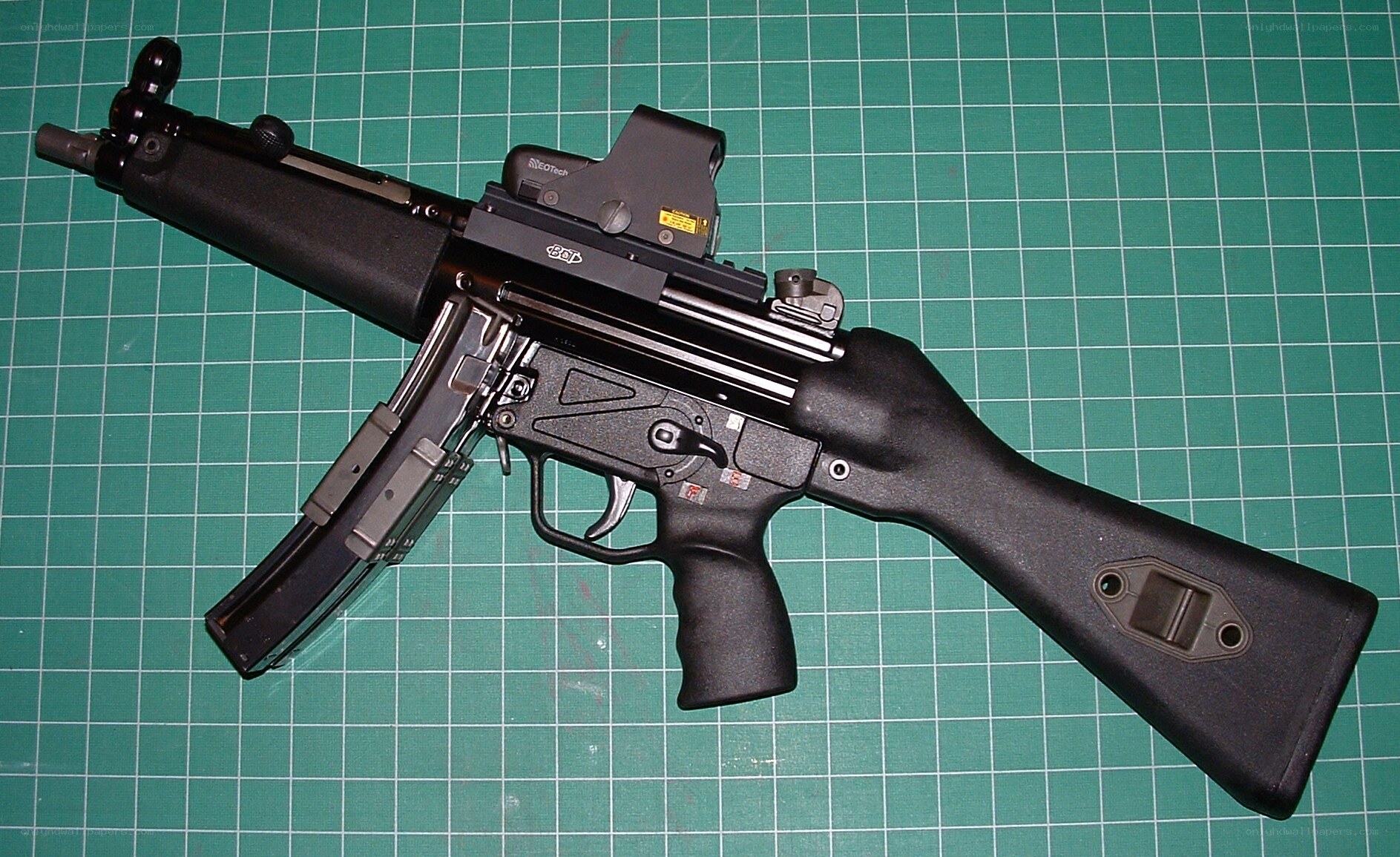 Black submachine gun on green mat