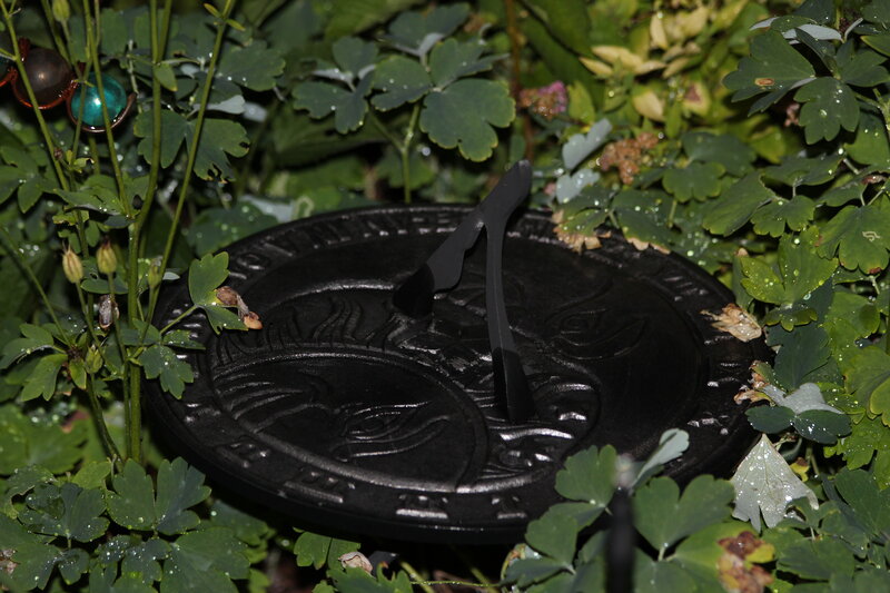 Black Sundial in Garden