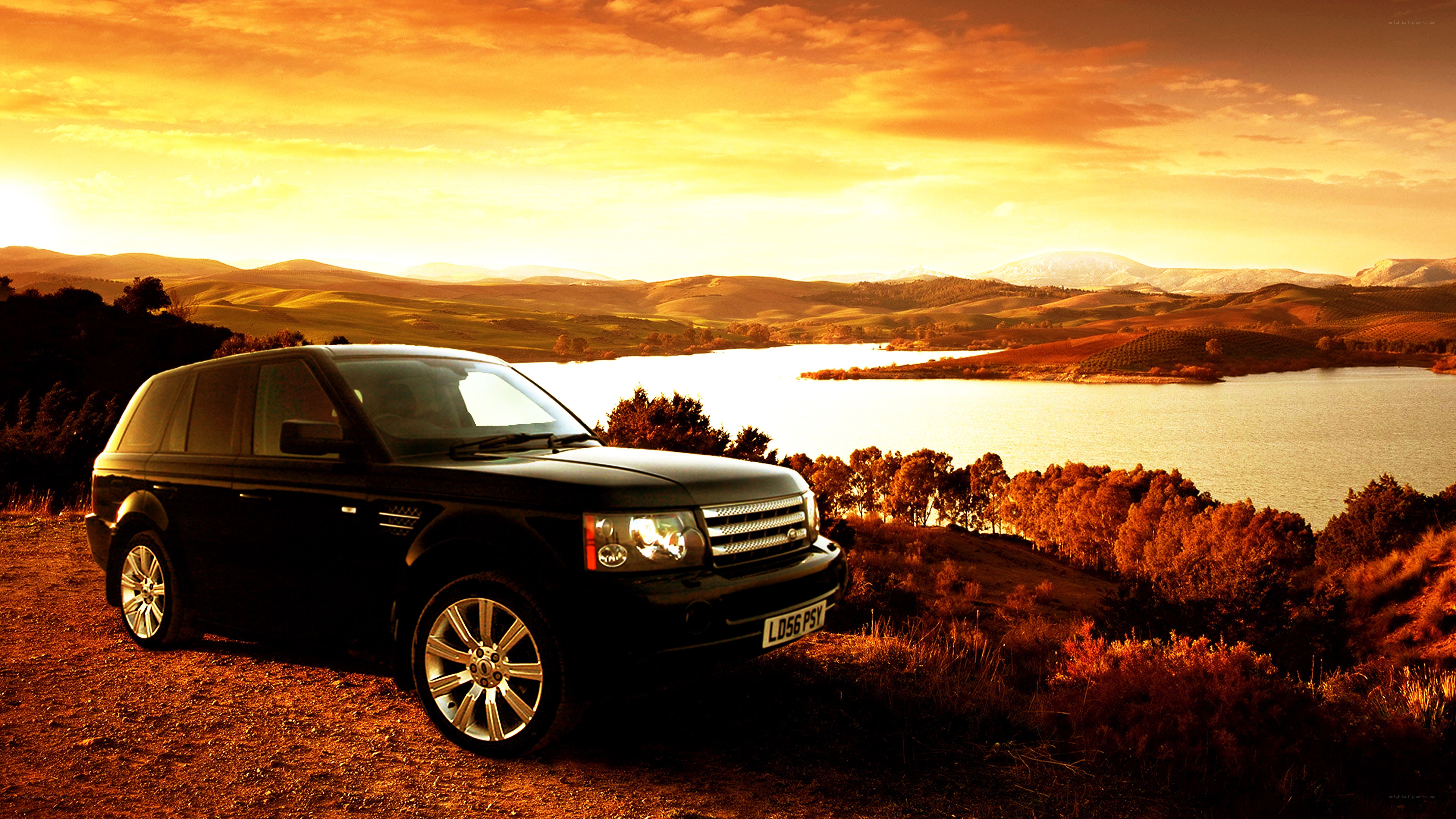 Black SUV at sunset by lake