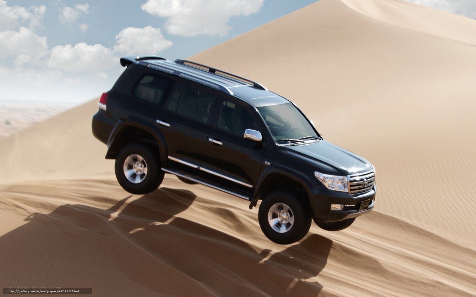 Black SUV on sand dune