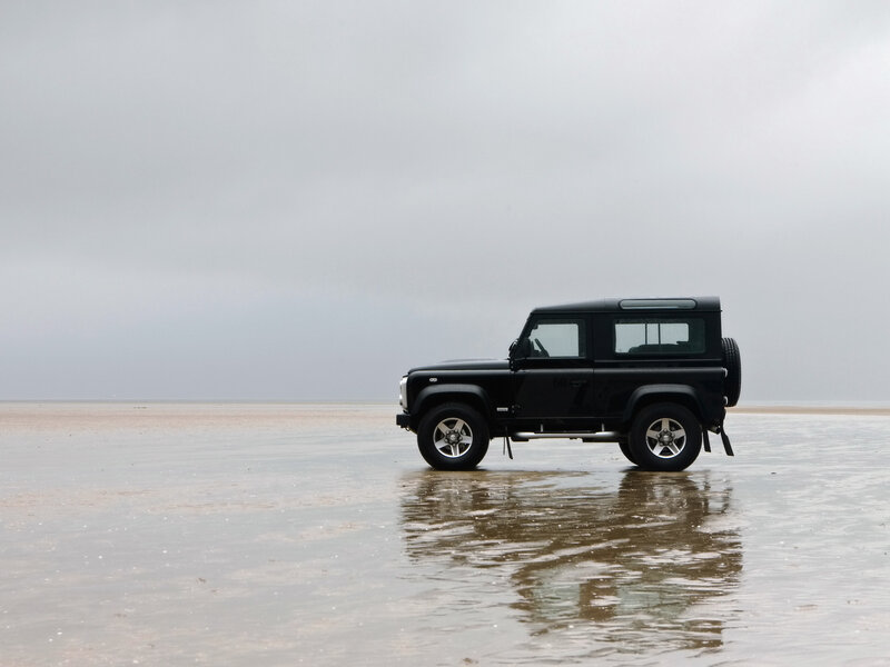 Black SUV on wet beach