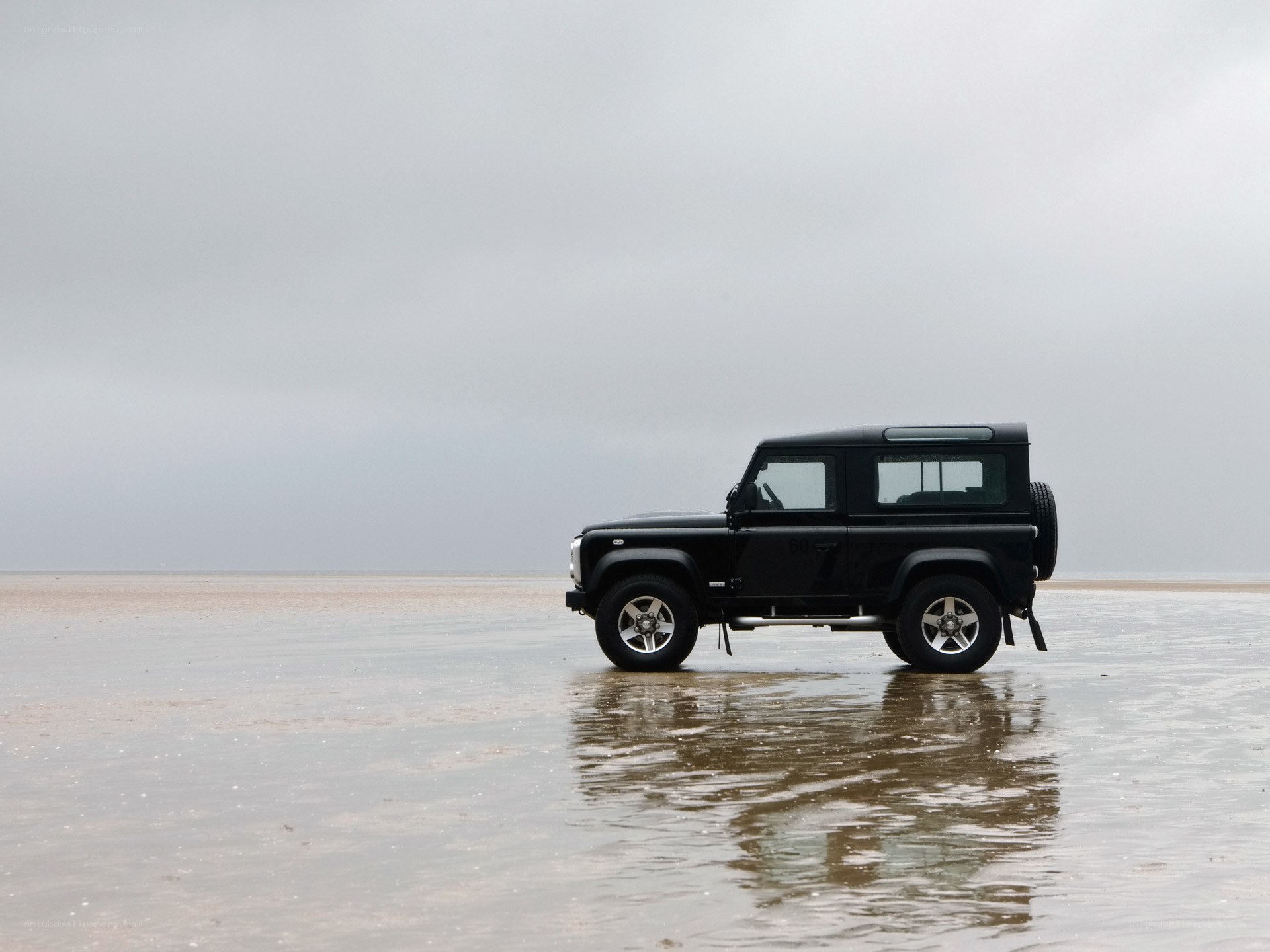 Black SUV on wet beach