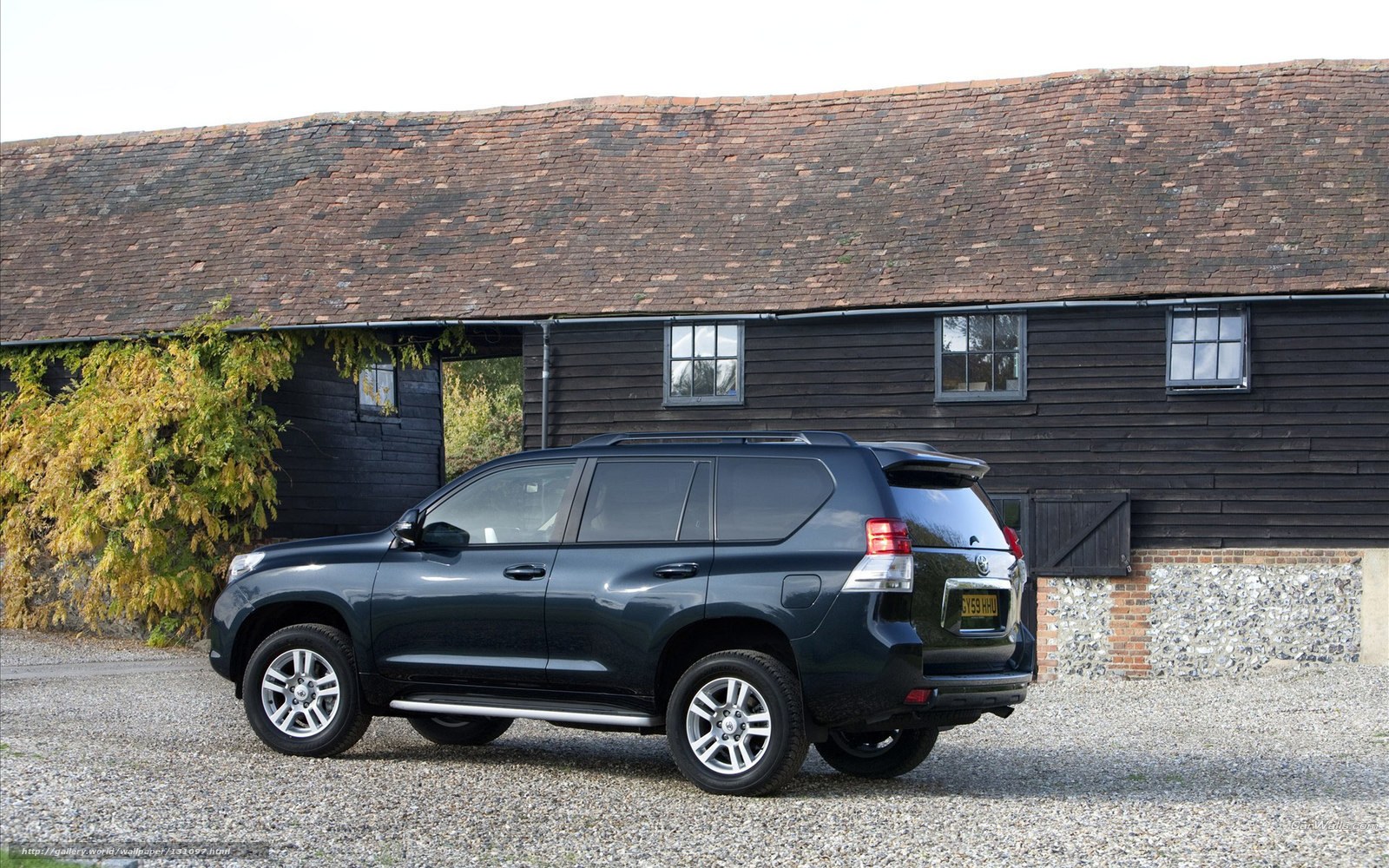 Black SUV parked in front of barn