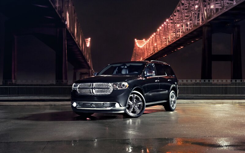 Black SUV under a bridge at night