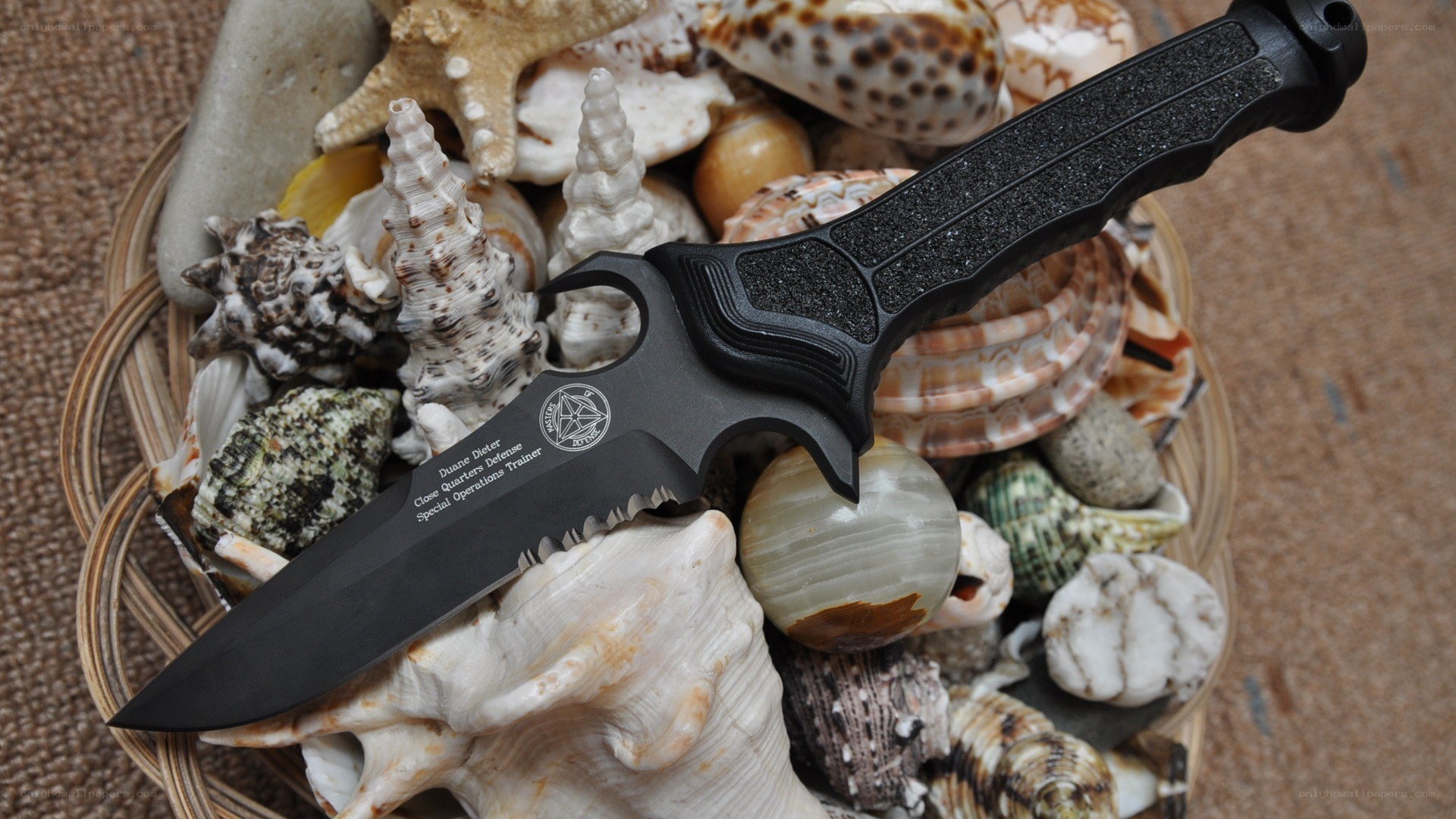 black tactical knife with seashells
