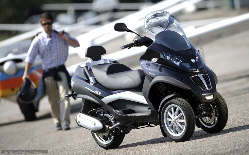 Black three-wheeled scooter on tarmac