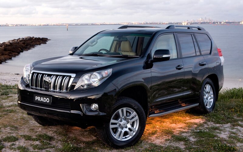 Black Toyota Prado by the water