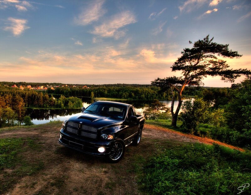 Black truck at sunset by lake