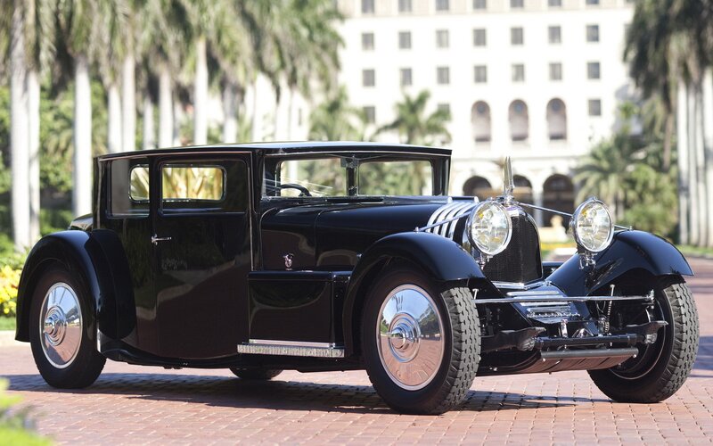 Black vintage car on brick driveway