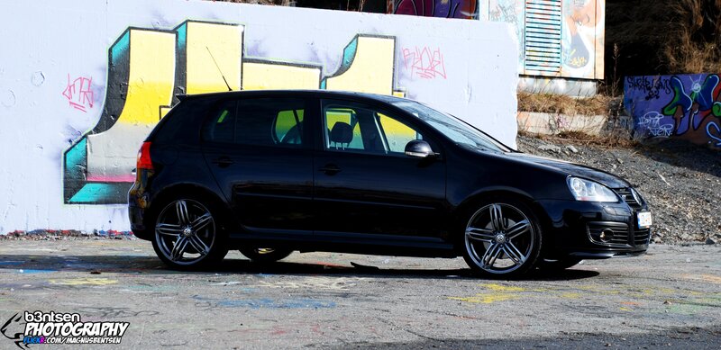 Black Volkswagen Golf parked in graffiti area