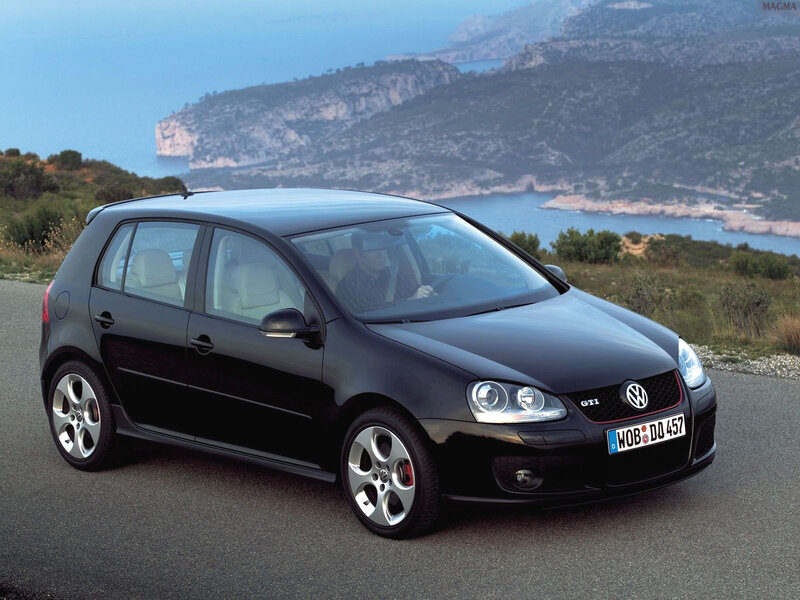 Black Volkswagen GTI on coastal road