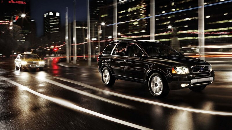 Black Volvo on city street at night
