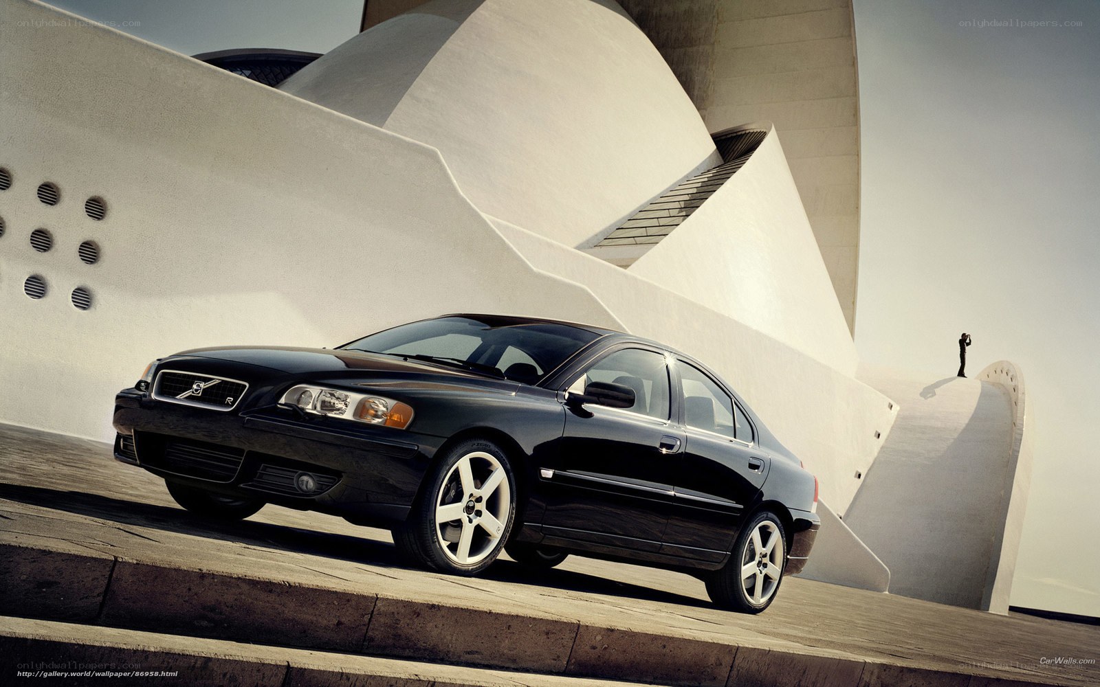 Black Volvo S60 in front of modern building