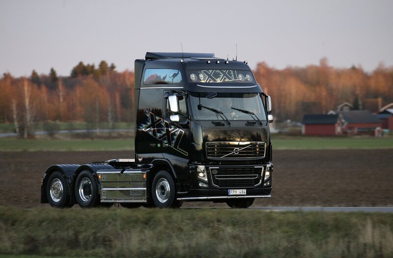 Black Volvo truck on a rural road