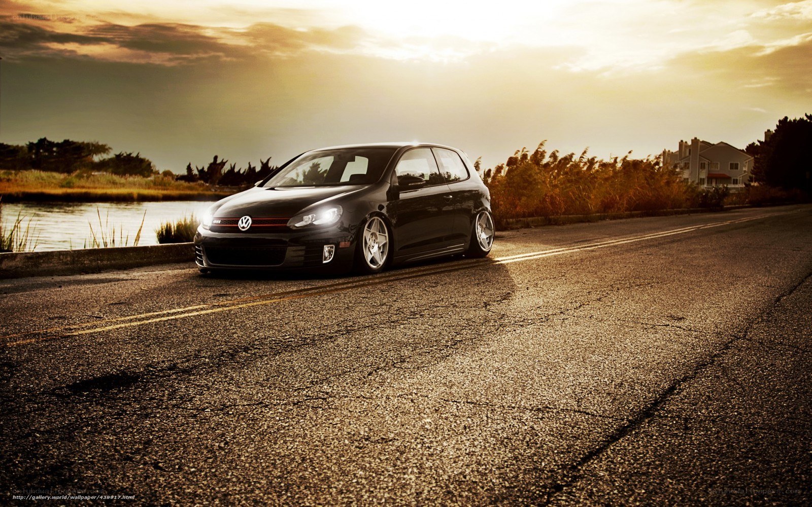 Black VW Golf on a road at sunset