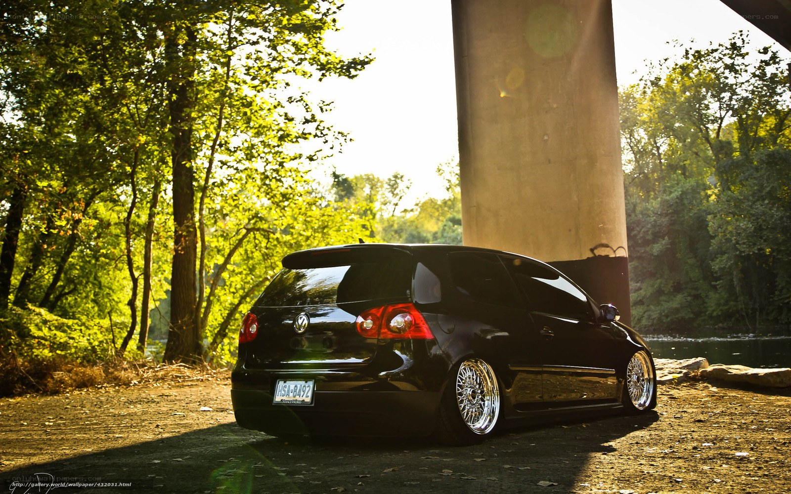 Black VW Golf under a bridge