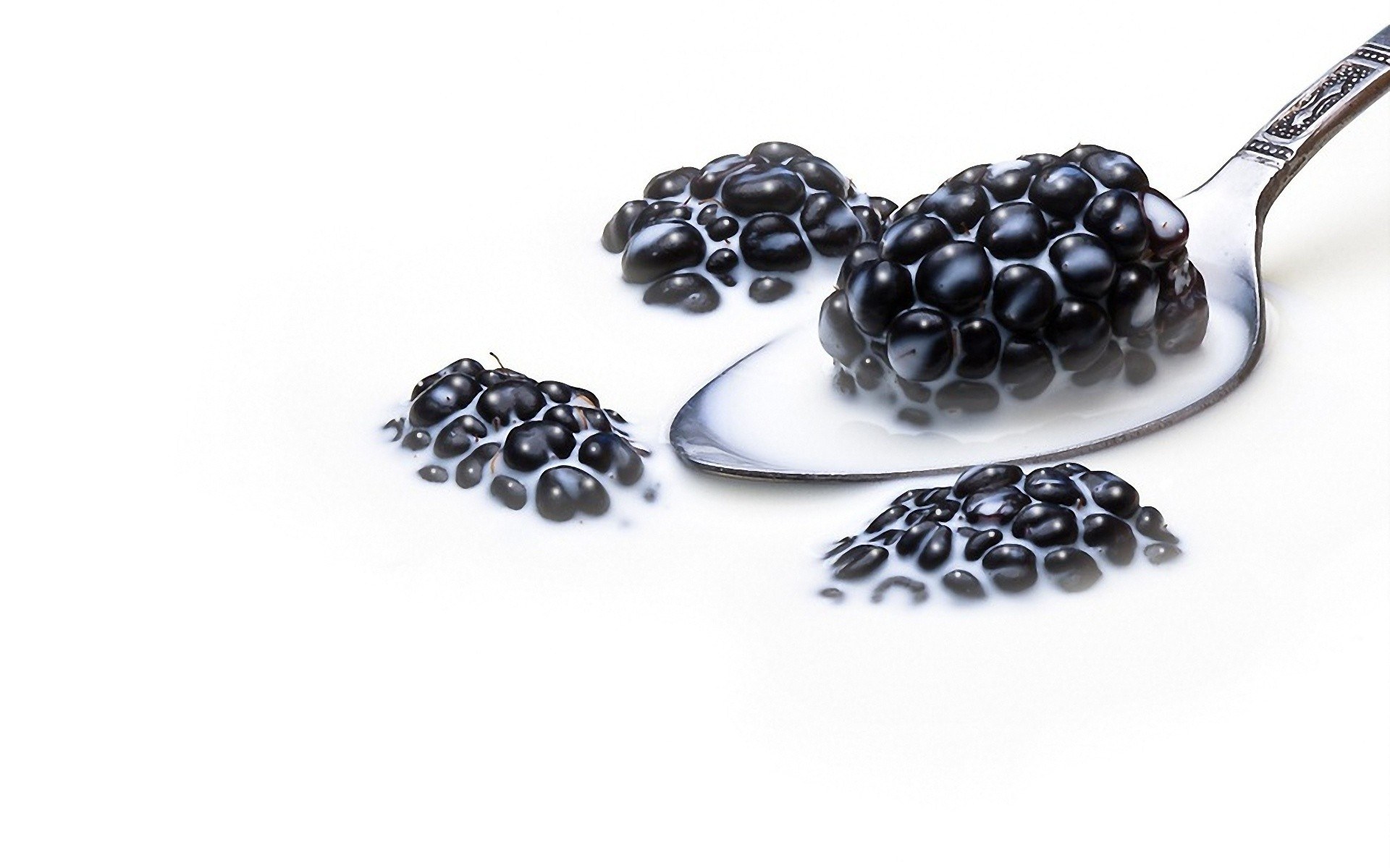 blackberries in milk on spoon