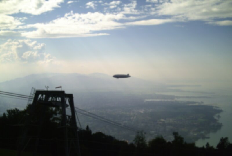 Blimp over a lake and mountains