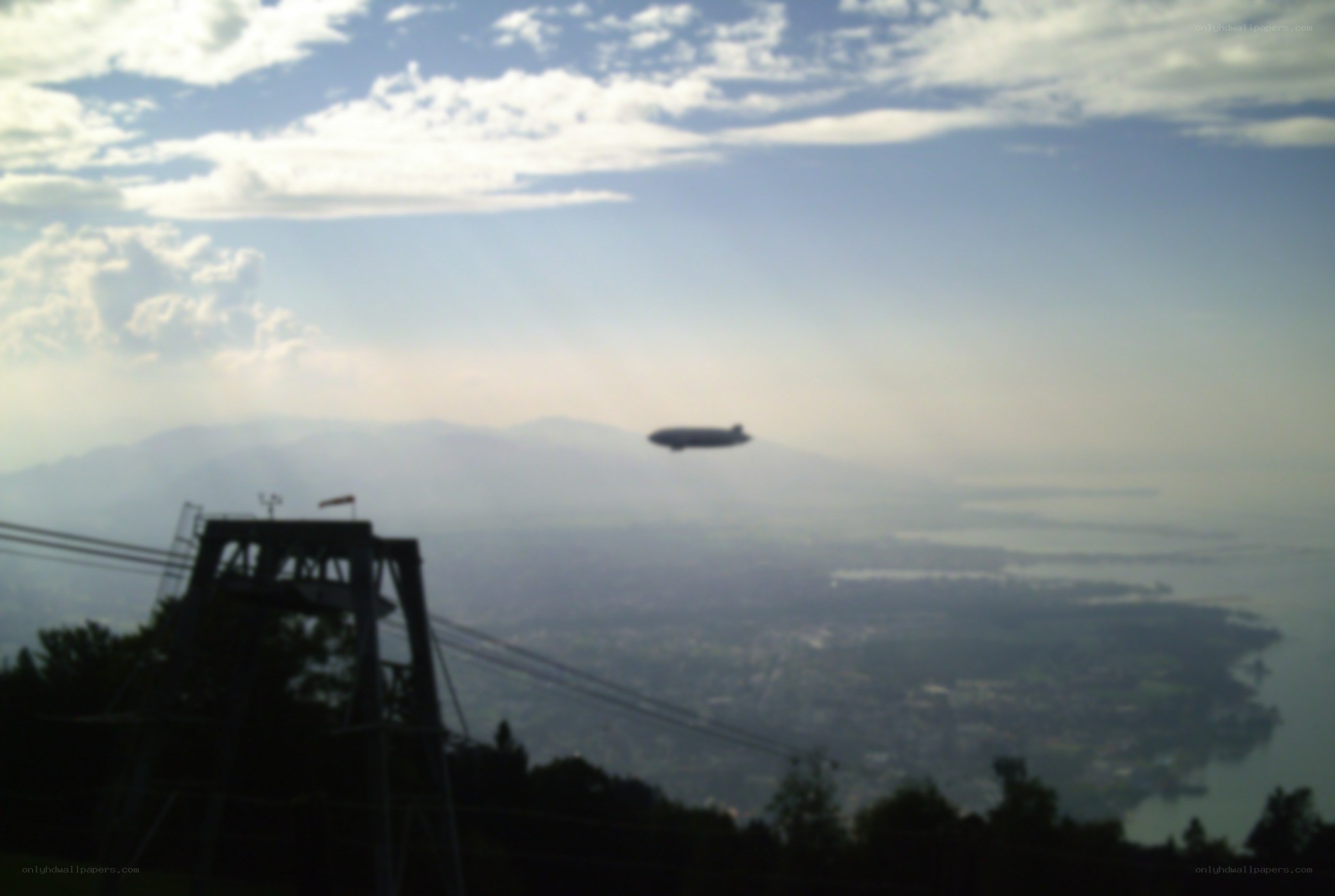 Blimp over a lake and mountains
