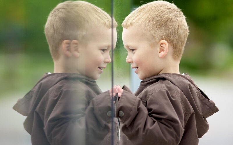 Blonde Boy Looking in Mirror
