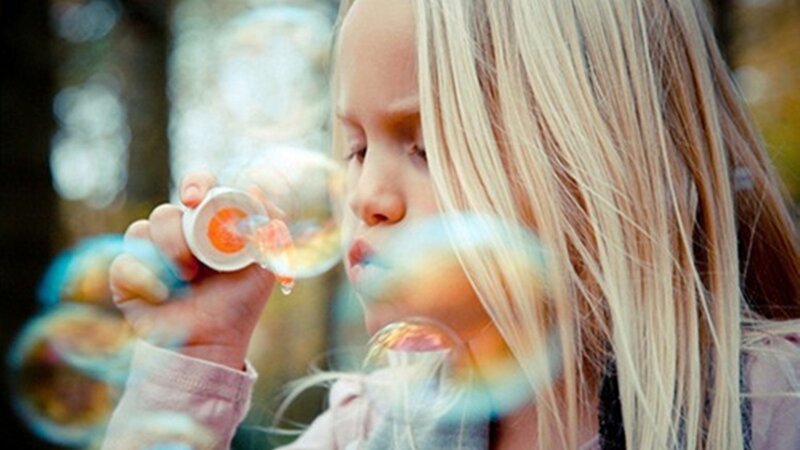 Blonde Girl Blowing Bubbles — Playful