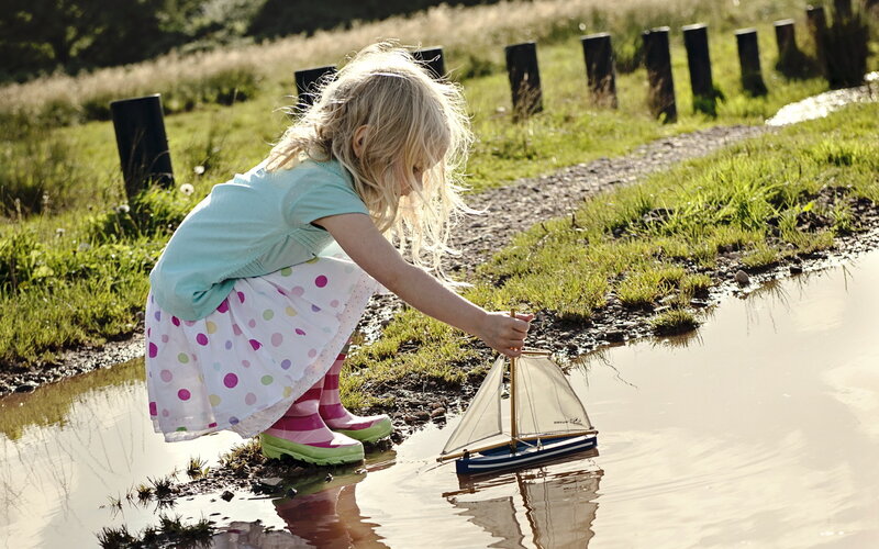 Blonde Girl Playing with Boat