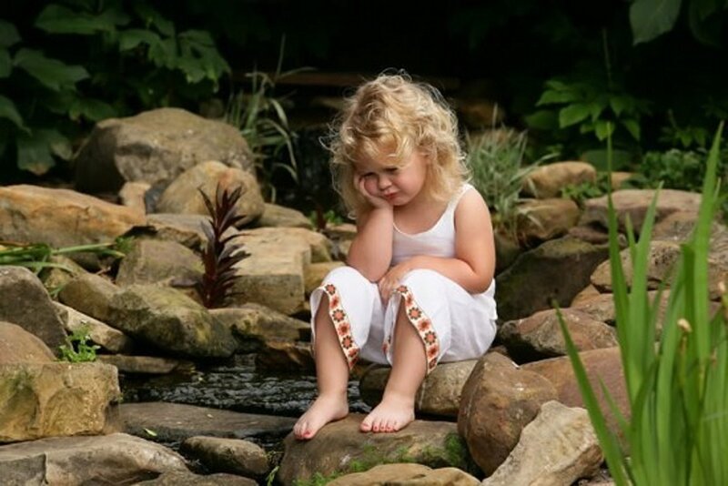 Blonde Girl Sitting on Rocks