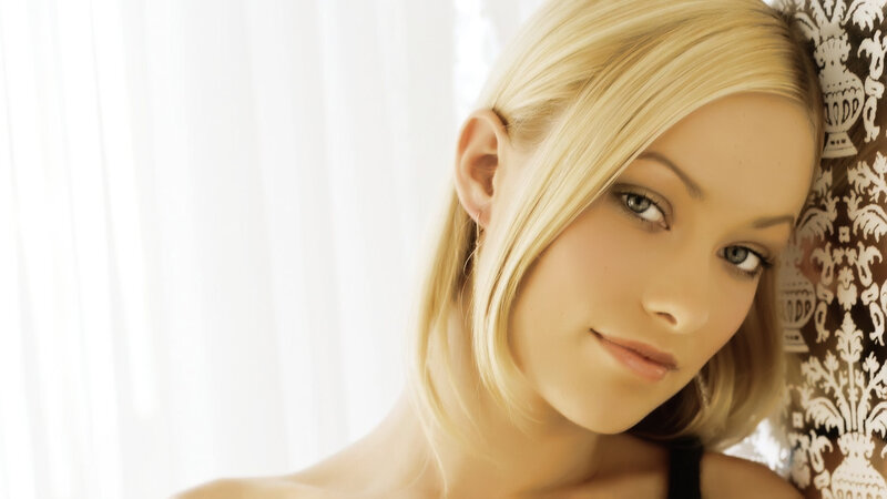 blonde woman leaning against wall