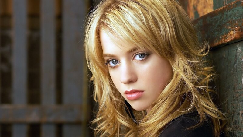 blonde woman leaning against wall