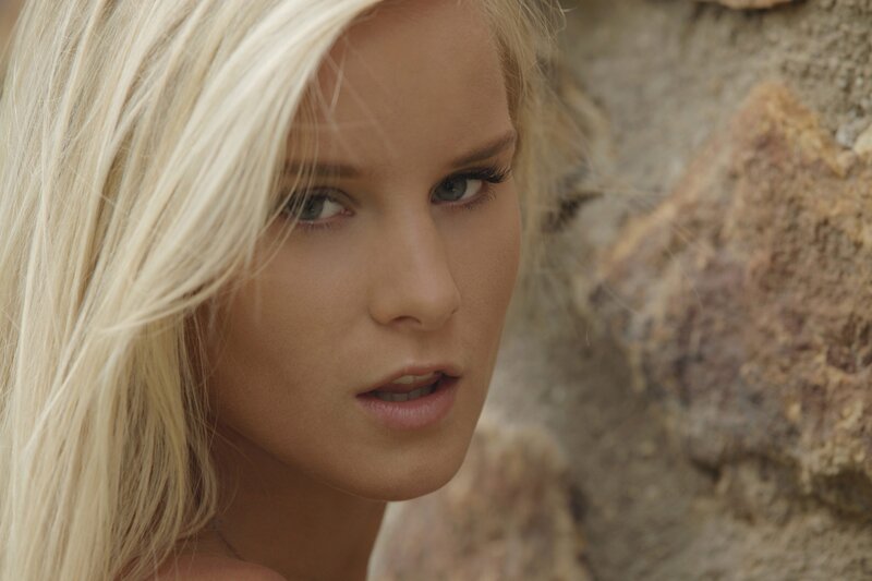 blonde woman near stone wall