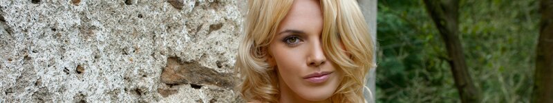 blonde woman near stone wall
