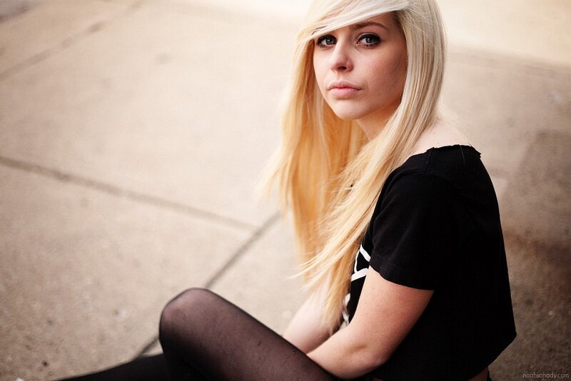blonde woman sitting on pavement